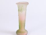 a pink and green vase sitting on a white surface