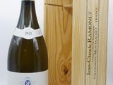 une bouteille de vin dans un coffret en bois à côté d'une bouteille de vin