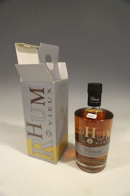 La bouteille de rhum se trouve à côté d'un carton, posée sur une surface blanche.