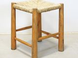an image of a wooden stool with a woven seat on it