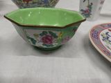 a green bowl sitting on top of a table next to a plate