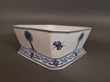 a blue and white planter with palm trees on it