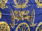 une écharpe bleue et dorée sur laquelle figure l'image d'un homme sur une roue