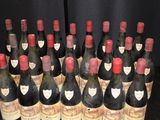 many bottles of wine that are lined up on a table