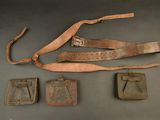 an old leather belt and other items on a gray surface