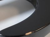 a close up of a black electric guitar on a white table