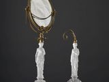 une paire de bougeoirs anciens en verre, accompagnés d'un miroir et d'une statuette