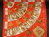 a red and white scarf with gold letters and symbols on it