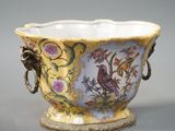 un vase jaune orné d'un oiseau et de fleurs
