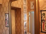 un miroir de salle de bains avec un cadre doré accroché au mur