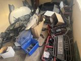 a pile of junk in a garage with a car in the background