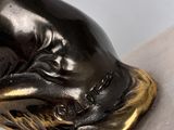 bronze statue of a hand holding a fish on a marble base