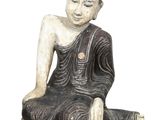 buddha statue sitting on a rock on a white background