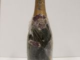 a bottle of wine wrapped in plastic and sitting on a table