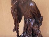 a statue of a woman holding a child on her back