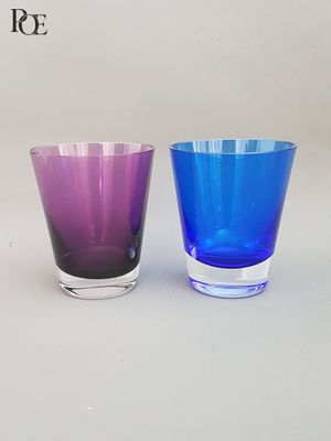 trois verres de couleurs différentes posés côte à côte sur une table