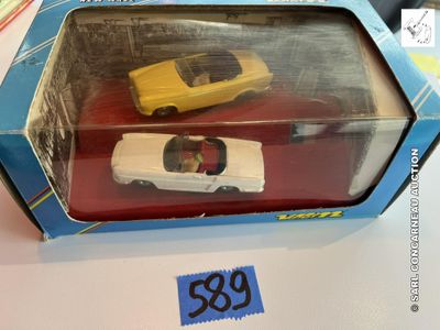 une boîte contenant deux petites voitures, posée sur une table