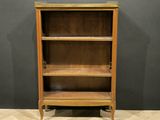 a wooden bookcase with three shelves on top of a herringle floor