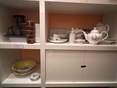 une étagère blanche sur laquelle sont posés une théière et un bol