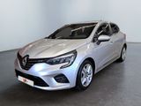 La voiture argentée est garée dans une pièce au sol noir.