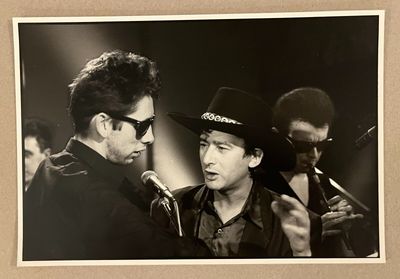 photographie en noir et blanc d'un homme coiffé d'un chapeau de cow-boy parlant dans un micro