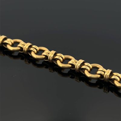 a close up of a gold bracelet on a black surface