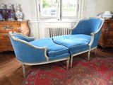 une chaise longue bleue posée sur un tapis rouge dans une pièce