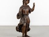 an antique bronze statue of a girl holding a basket and waving
