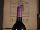a bottle of wine sitting on a table next to a book