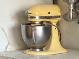 a yellow mixer and a whisk in a kitchen