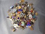 a pile of assorted pins and badges on a table