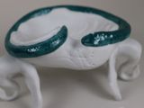 a white and green crab figurine sitting on a table