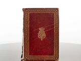 a red book sitting on a table with a gold emblem on it