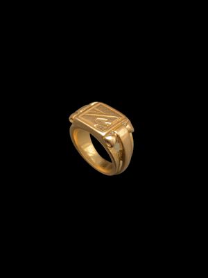 gros plan d'une bague en or sur fond noir