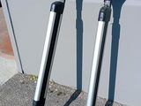 two black and silver crutches sitting on the sidewalk