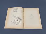 an open book on a blue surface with a drawing of a man in a chair