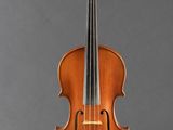an old violin sitting on a stand against a gray background