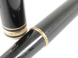 a black fountain pen with a gold trim and a black nib