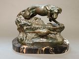 statue of a dog jumping over a rock on a marble base