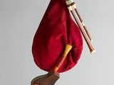 a red bag with a musical instrument hanging from it ' s side
