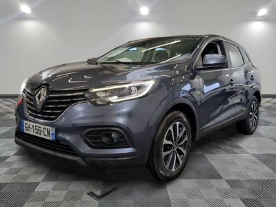 une voiture grise est garée sur le sol à carreaux d'un garage
