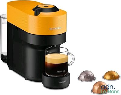 gros plan d'une tasse de café à côté d'une cafetière