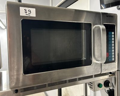 a microwave that is on a stand in the kitchen