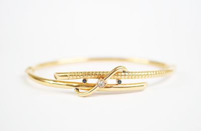 un gros plan d'une bague en or surmontée d'un nœud