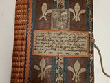 an old book sitting on top of a white table covered in writing