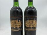 deux bouteilles de vin rouge posées l'une à côté de l'autre sur une surface blanche