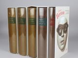three books are lined up in a row on a gray surface