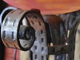 a close up of a sewing machine with a clock in the background