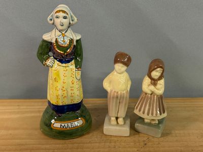deux figurines représentant une femme et un enfant posées sur une table en bois