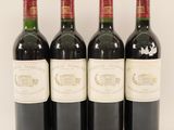 four bottles of wine are lined up on a white surface